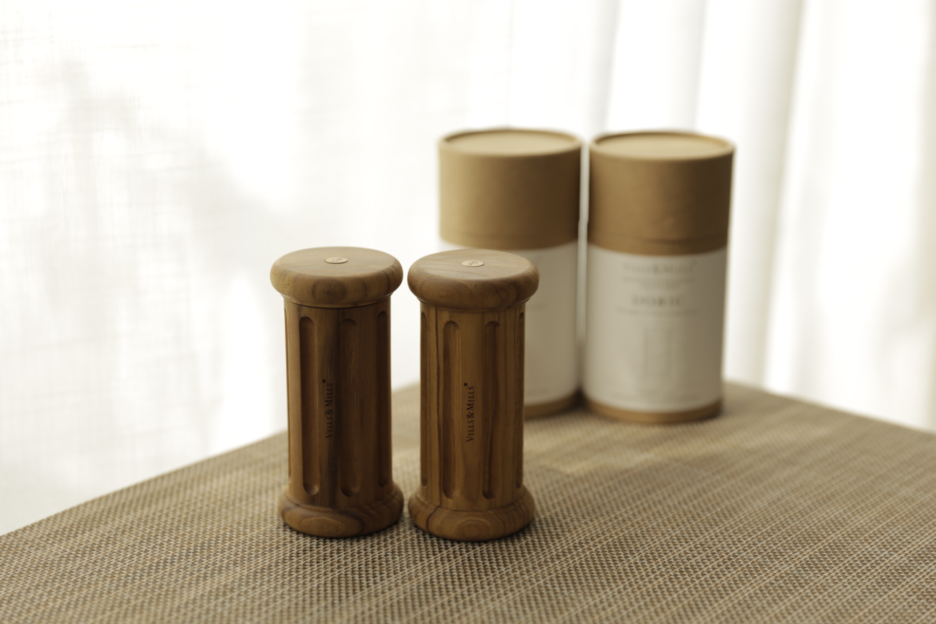 Doric salt and pepper mills — straight fluted teak columns beside their DORIC packaging tubes